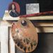 Trompe-l'œil recortado con un trozo de fruta - Cornelius Norbertus Gijsbrechts — presentado en un interior