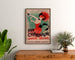 Póster publicitario vintage Champagne Damery-Épernay, enmarcado sobre una cómoda de madera, entre plantas.