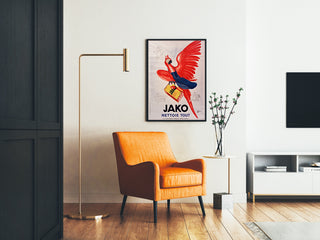 Póster publicitario vintage Jako limpia todo, enmarcado en un salón con un sillón naranja y una lámpara de pie.