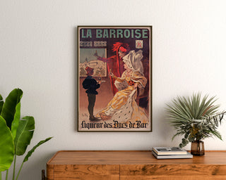 Póster publicitario vintage La Barroise, enmarcado sobre una cómoda de madera, entre plantas.
