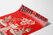 Póster publicitario vintage Paris-Dijon, juguetes y regalos, presentado sobre una hoja curvada, visto en perspectiva.