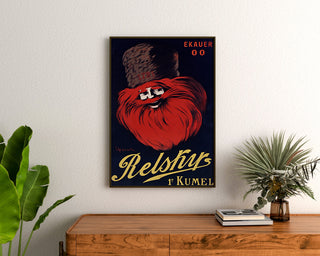 Póster publicitario vintage Relskyr - 1° Kumel, enmarcado sobre una cómoda de madera, entre plantas.