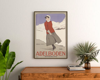 Póster Suiza vintage – Adelboden – Carlo Pellegrini, 1905, enmarcado sobre una cómoda de madera, entre plantas.