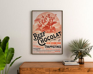 Póster vintage Beef Chocolat, chocolatería de la Drôme, enmarcado sobre una cómoda de madera, entre plantas.