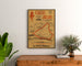 Vintage Circuit d’Anjou poster, walking, framed above a wooden chest of drawers, between plants.