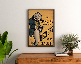 Póster vintage La Sardine française, Béziers, enmarcado sobre una cómoda de madera, entre plantas.