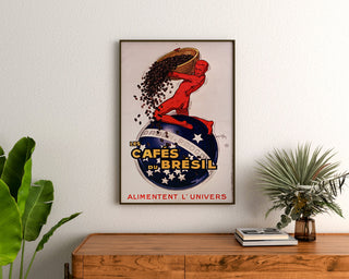 Vintage Les Cafés du Brésil poster, framed above a wooden dresser between plants.