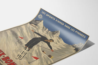 Póster vintage Les Eaux-Bonnes, deportes de invierno, presentado sobre una hoja curvada, visto en perspectiva.