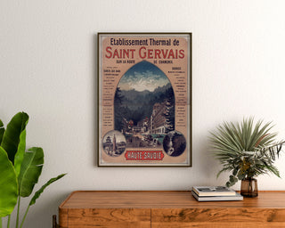 Cartel vintage Saint-Gervais, balneario, enmarcado sobre una cómoda de madera, entre plantas.
