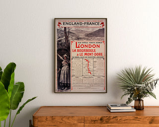 Póster vintage South Eastern, England-France, enmarcado sobre una cómoda de madera, entre plantas.