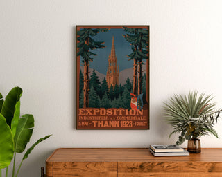 Póster vintage de Thann, exposición industrial, enmarcado sobre una cómoda de madera, entre plantas.