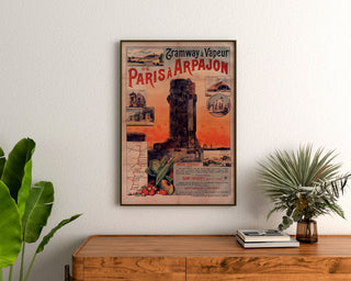 Póster vintage Tramway Paris-Arpajon, enmarcado sobre una cómoda de madera, entre plantas.