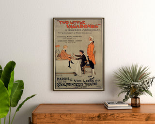 Cartel vintage Two Little Vagabonds, enmarcado sobre una cómoda de madera, entre plantas.
