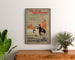 Cartel vintage Two Little Vagabonds, enmarcado sobre una cómoda de madera, entre plantas.