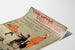 Cartel vintage Two Little Vagabonds, presentado sobre una hoja curvada, visto en perspectiva.