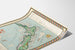 Antique map of New Zealand – MacDonald Gill, 1931, shown on a curved sheet, viewed in perspective.